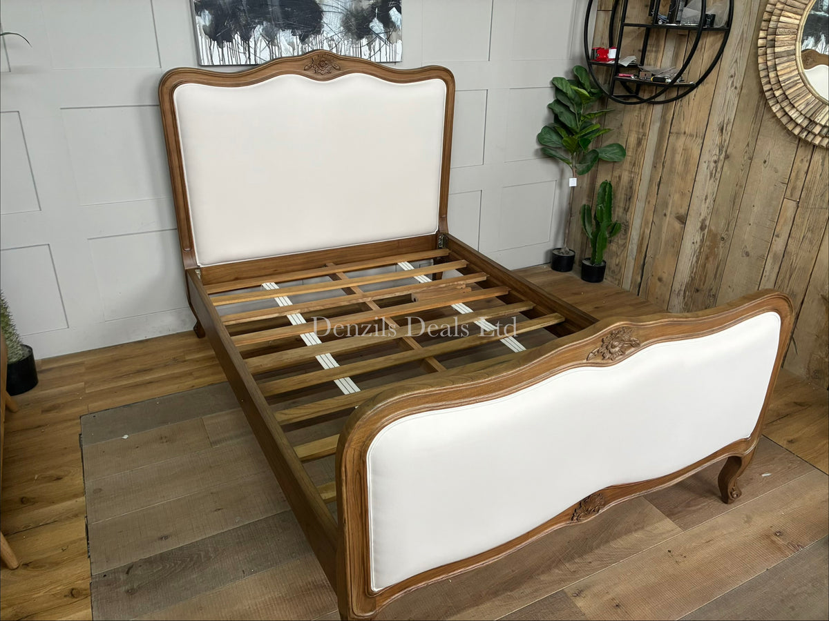 The Homesdirect365 Montpellier Antique French Style Bed frame, meticulously hand-crafted from solid Mindy wood. The bed showcases an elegant vintage design with a soft whitewash cream finish highlighting its natural wood grains. It features an ornately carved, subtly arched headboard and footboard, elegantly curved cabriole legs, and a sturdy slatted foundation layout