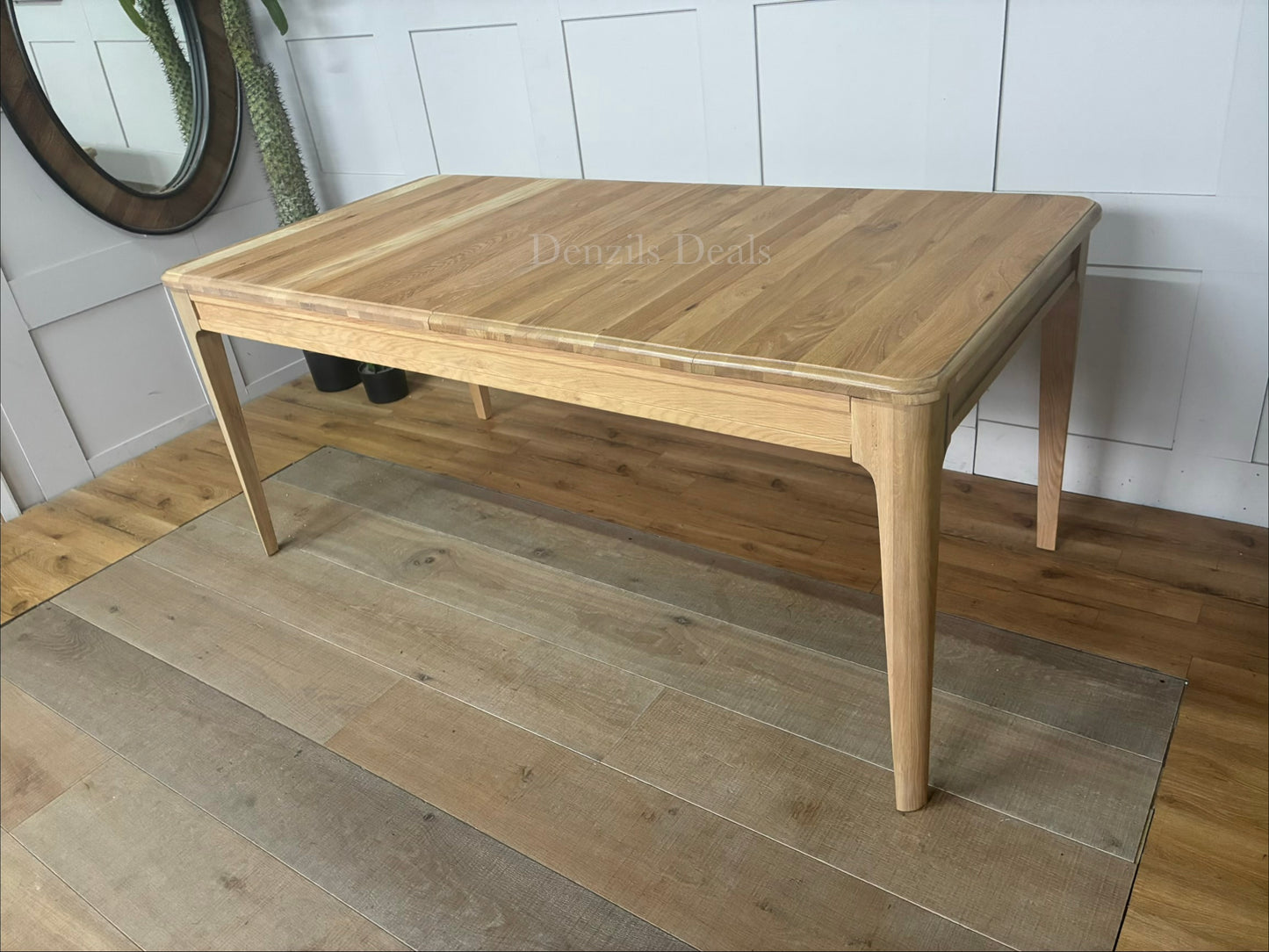 NEWTON light natural solid oak 6 to 8 seater extendable dining table with a pale oak finish."