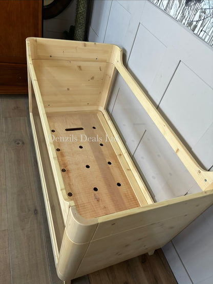 Natural wood baby cot bed with transparent acrylic sides.