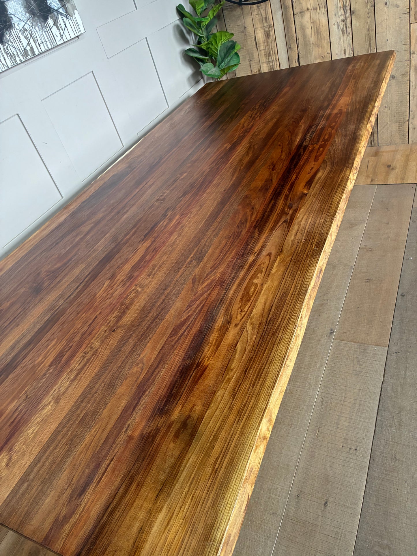 Image of the Nick Scali Bartolo dining table. It features a smooth, natural-finish Blackwood timber surface with distinct wood grain variations and unique, wavy live edges along the sides. The rectangular top is supported by thick, industrial black metal sleigh legs, offering a modern yet rustic dining setup