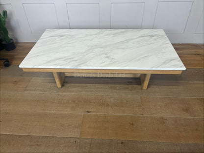 Nick Scali Carlina marble coffee table placed in a modern living room, styled with a solid timber frame and warm wood apron."