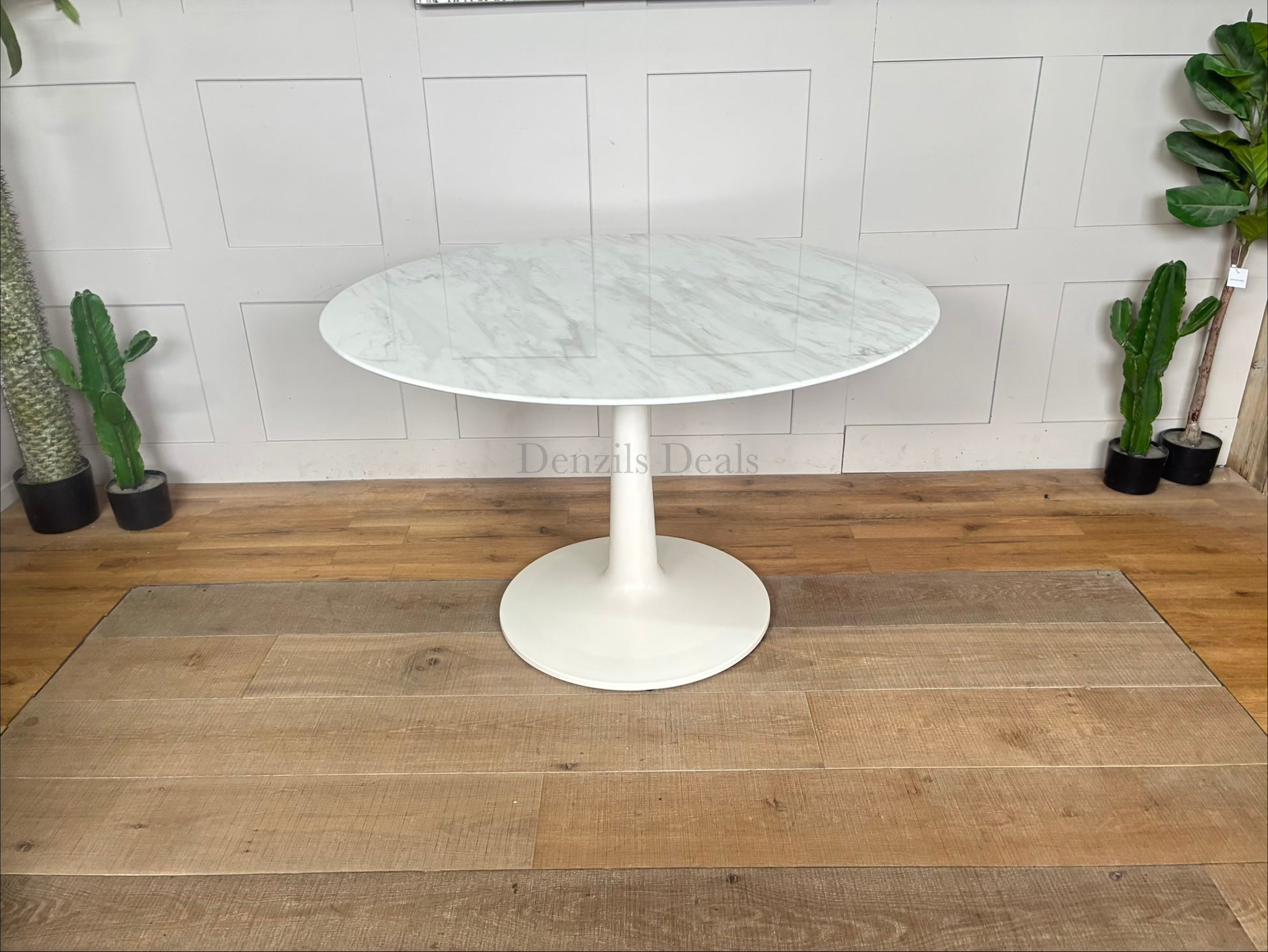 Traver round dining table by Nick Scali, featuring a smooth, matte travertine-wrapped top resting on a sculptural, wave-like white-washed oak pedestal base.