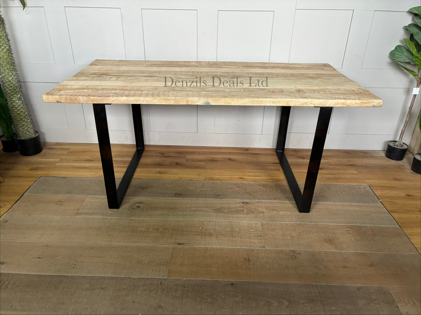 "Nkuku Fia 6-seater dining table with a natural mango wood tabletop and a dark, angular iron frame base