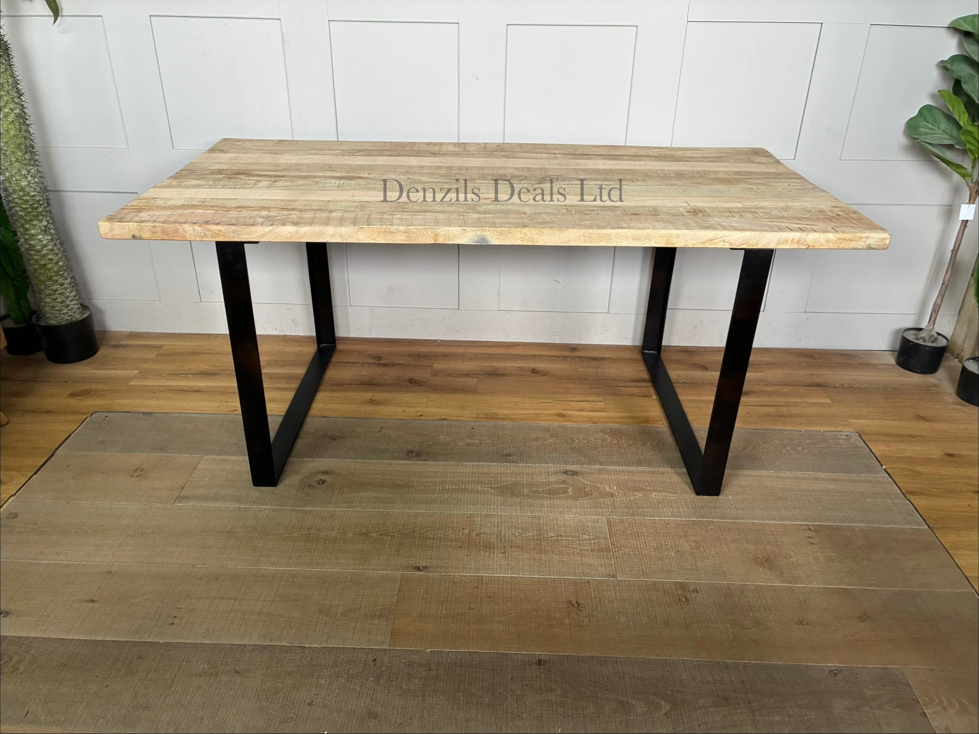 "Nkuku Fia 6-seater dining table with a natural mango wood tabletop and a dark, angular iron frame base