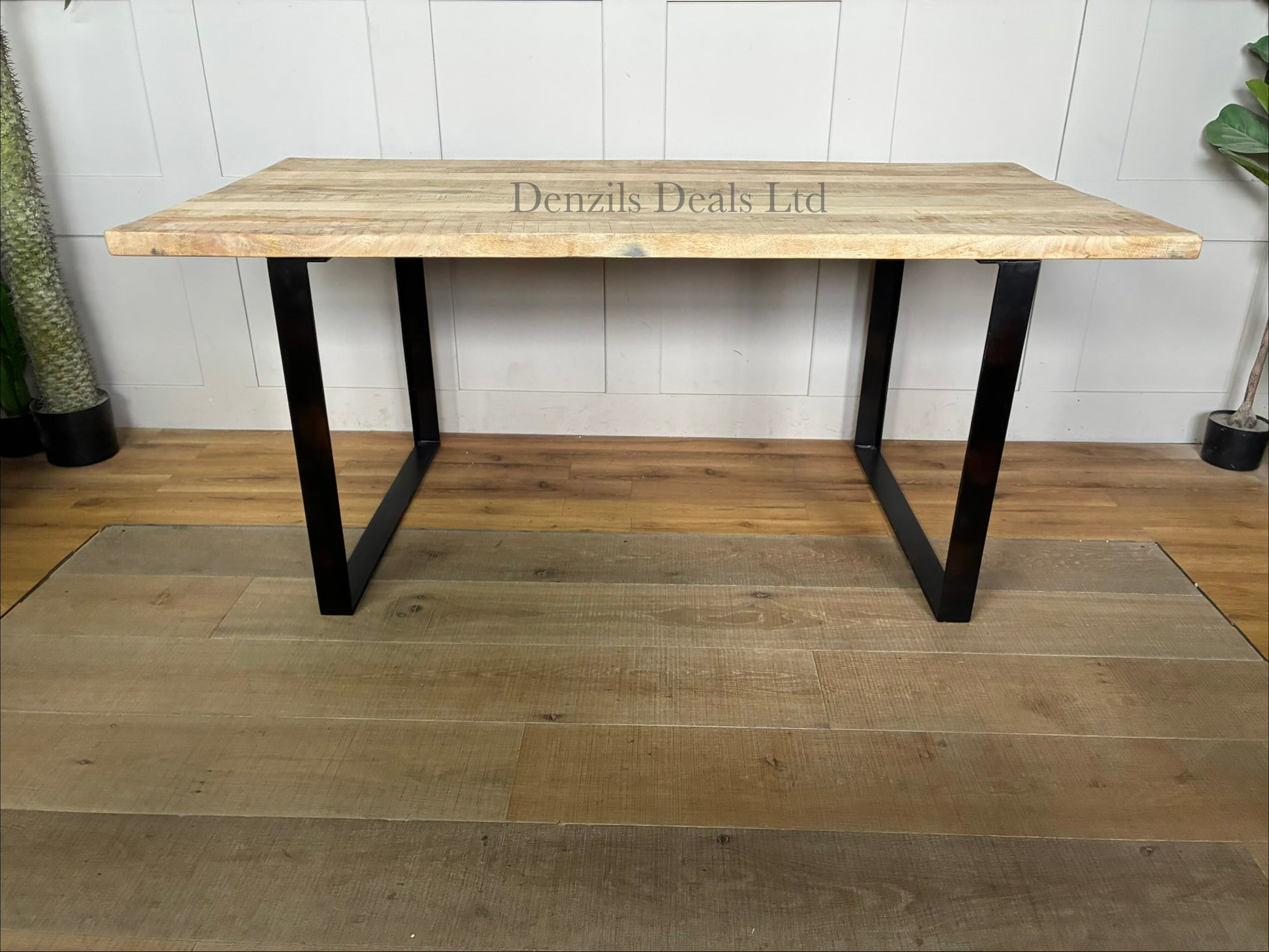 "Nkuku Fia 6-seater dining table with a natural mango wood tabletop and a dark, angular iron frame base
