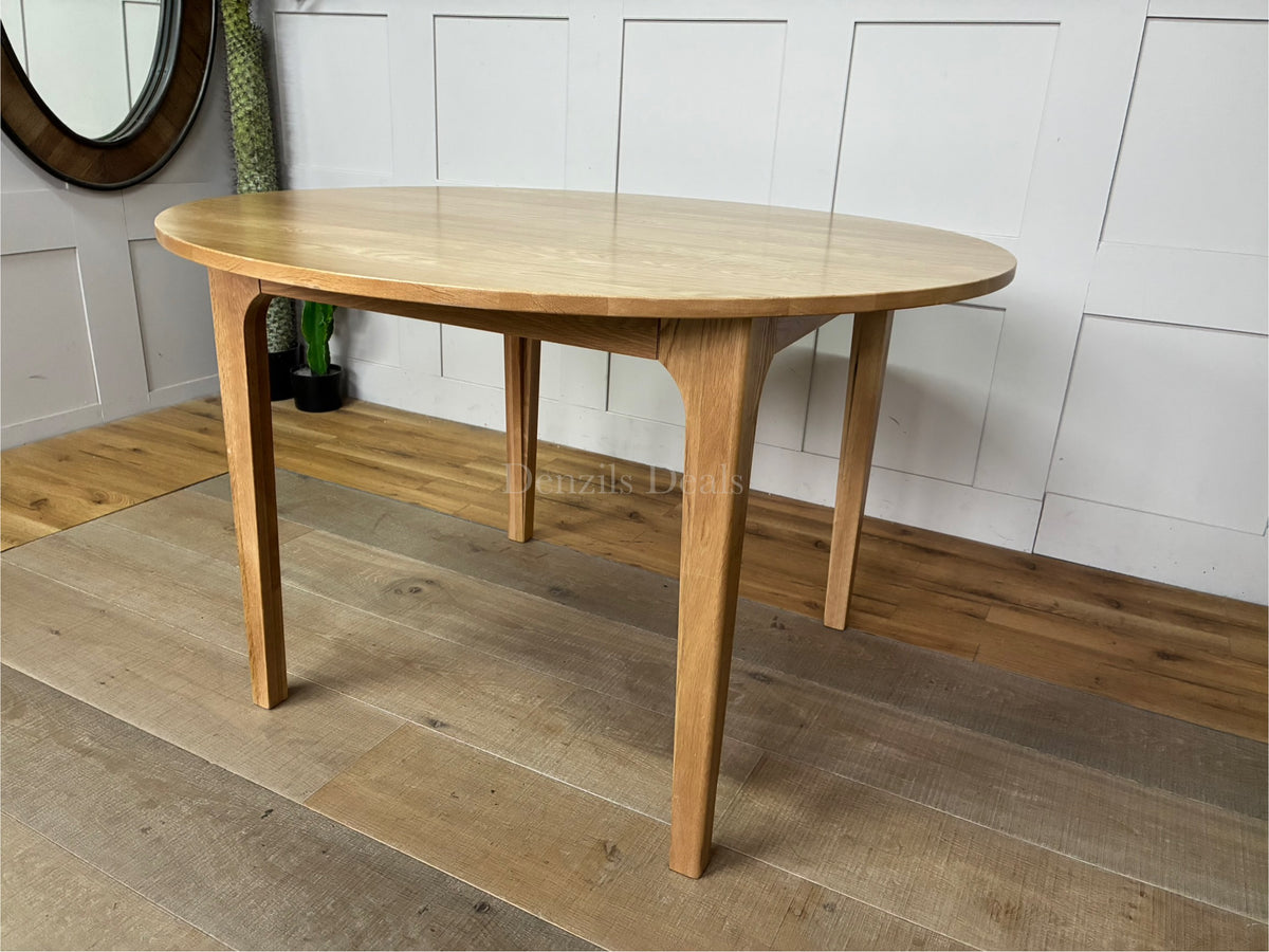 OAK ROUND DINING TABLE 120CM DURHAM NATURAL By OAK FURNITURELAND a Scandinavian-inspired, solid oak piece designed with gently curved legs and a clear natural finish that highlights the authentic wood grain.