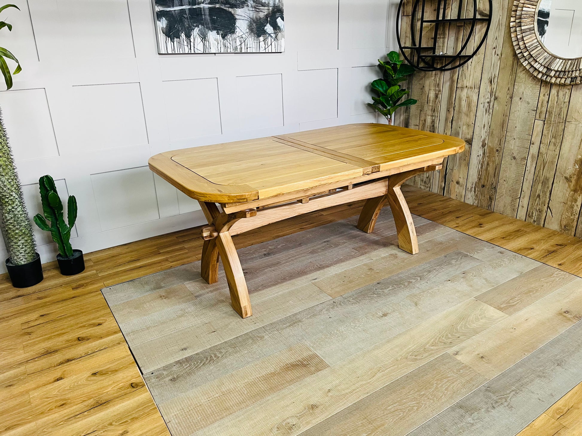 Oak Furnitureland Hercules natural solid oak extending dining table with cross-arched legs, shown at its full 280cm length to seat 10 to 12 people."