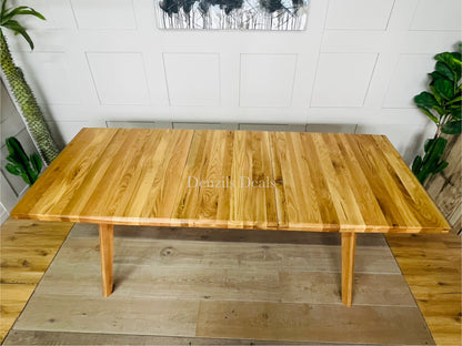 Oaklee natural oak dining table shown with central butterfly extension mechanism partially opened.