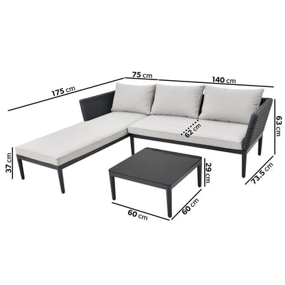 Outdoor black wicker L-shaped sofa with a chaise longue, beige cushions, and a matching coffee table set on a garden patio.