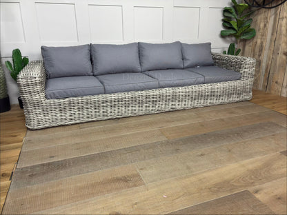 Gallery Direct Ragusa 3-seater garden sofa featuring a natural 9mm rounded weave poly-rattan finish, thick ivory showerproof cushions, and an aluminium frame on a sunny patio