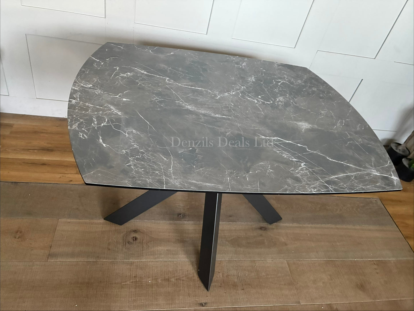 Rhodes Twist Top Extending Dining Table with a printed glass HPL (High-Pressure Laminate) finish. Contemporary twist-top expanding mechanism where the central section rotates or slides open to reveal extra surface area.