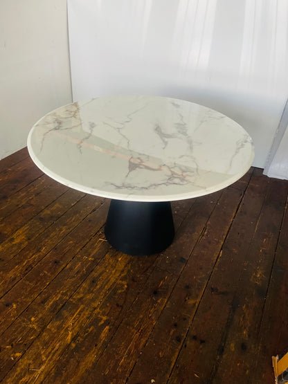 Richmond Degas 120cm round dining table featuring a sleek, smooth white faux marble top resting on a bold, conical matte black metal pedestal base
