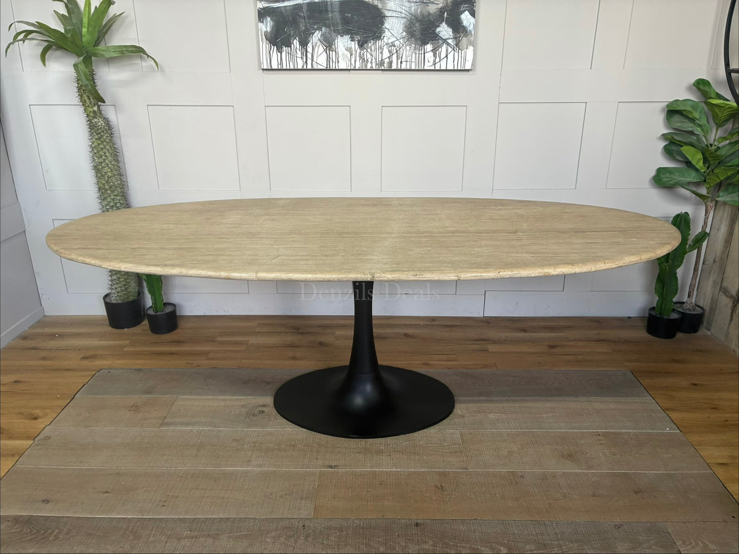 Richmond Interiors Hampton 8-seater oval dining table featuring a natural beige travertine stone oval top and modern black iron pedestal."