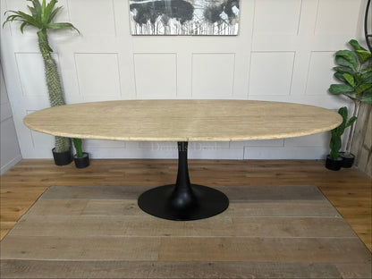 Richmond Interiors Hampton 8-seater oval dining table featuring a natural beige travertine stone oval top and modern black iron pedestal."
