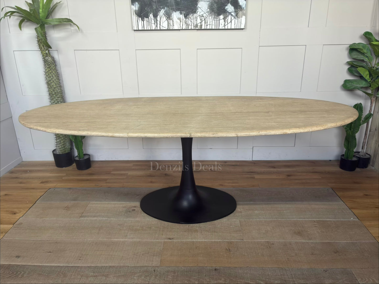 Richmond Interiors Hampton 8-seater dining table featuring a natural beige travertine stone oval top and modern black iron pedestal."