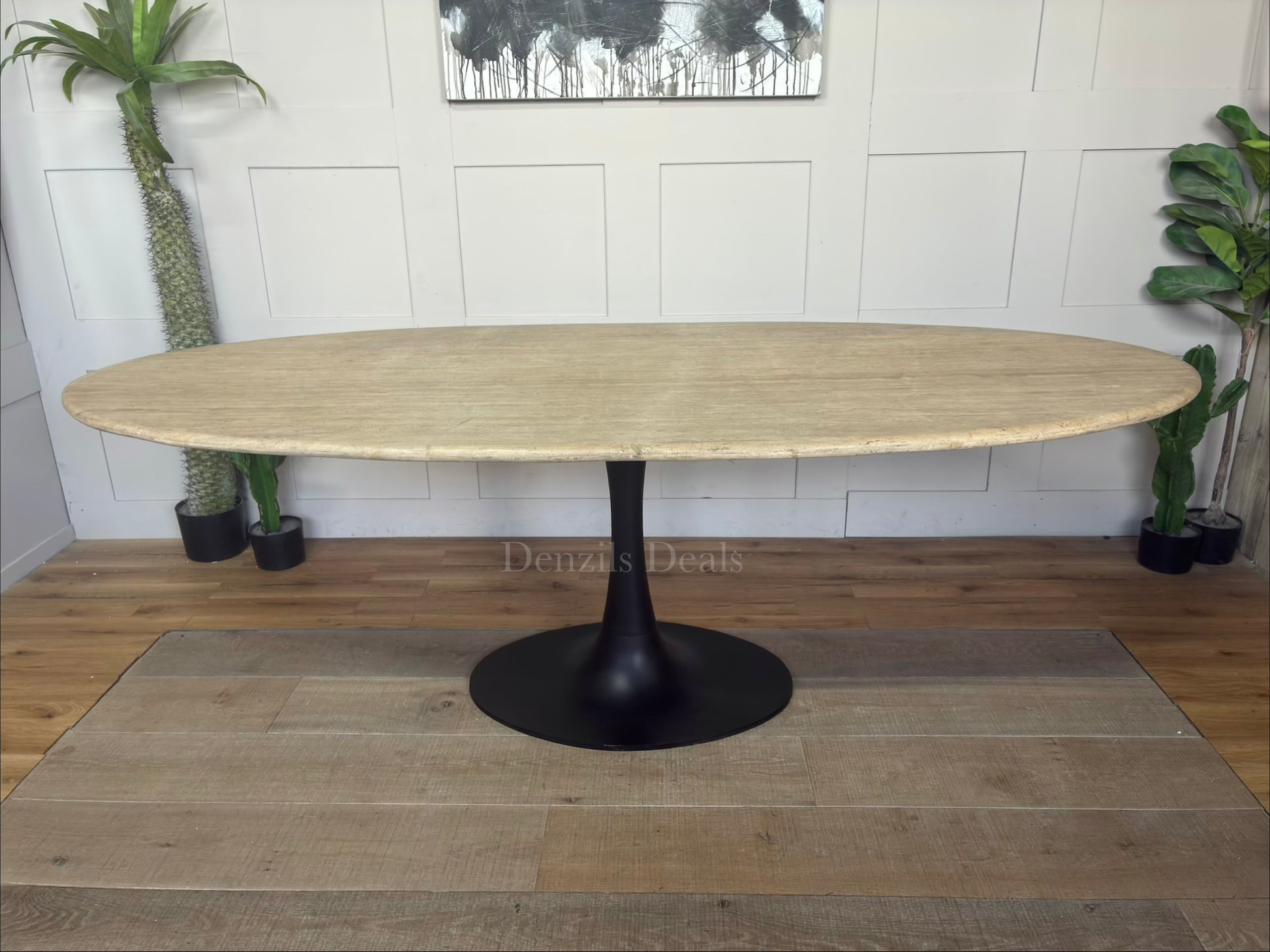 Richmond Interiors Hampton 8-seater dining table featuring a natural beige travertine stone oval top and modern black iron pedestal."
