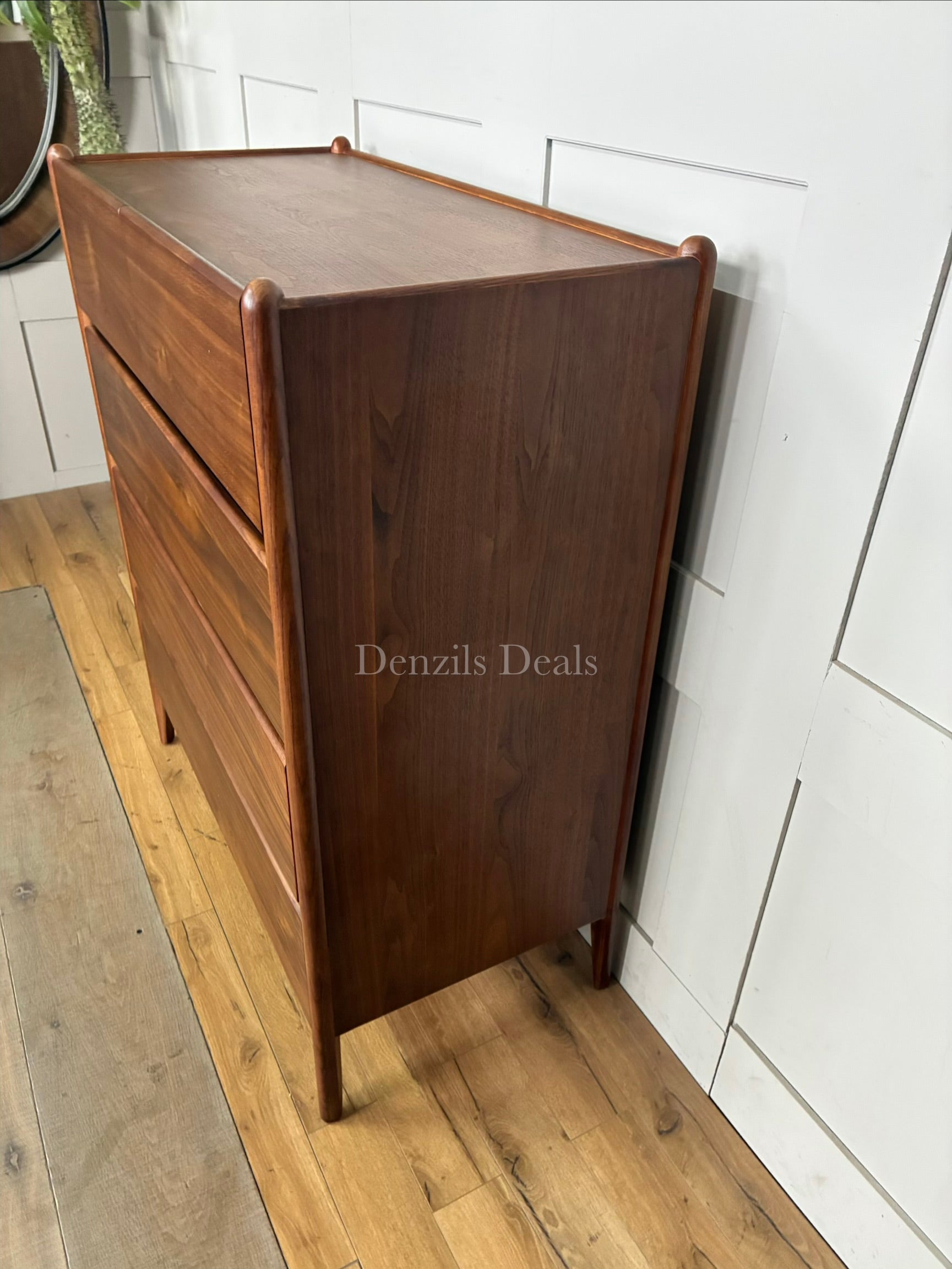 John Lewis Scandi 5 Drawer Wood Chest, Walnut Finish with five storage drawers and the top surface has a slight tray-edge design so your bedside essentials stay secure. Rounded posts, tapered legs and sleek, handle-less drawers all honour Scandinavian design principles, so it's perfect for keeping your bedroom a calm, uncluttered and simple space.