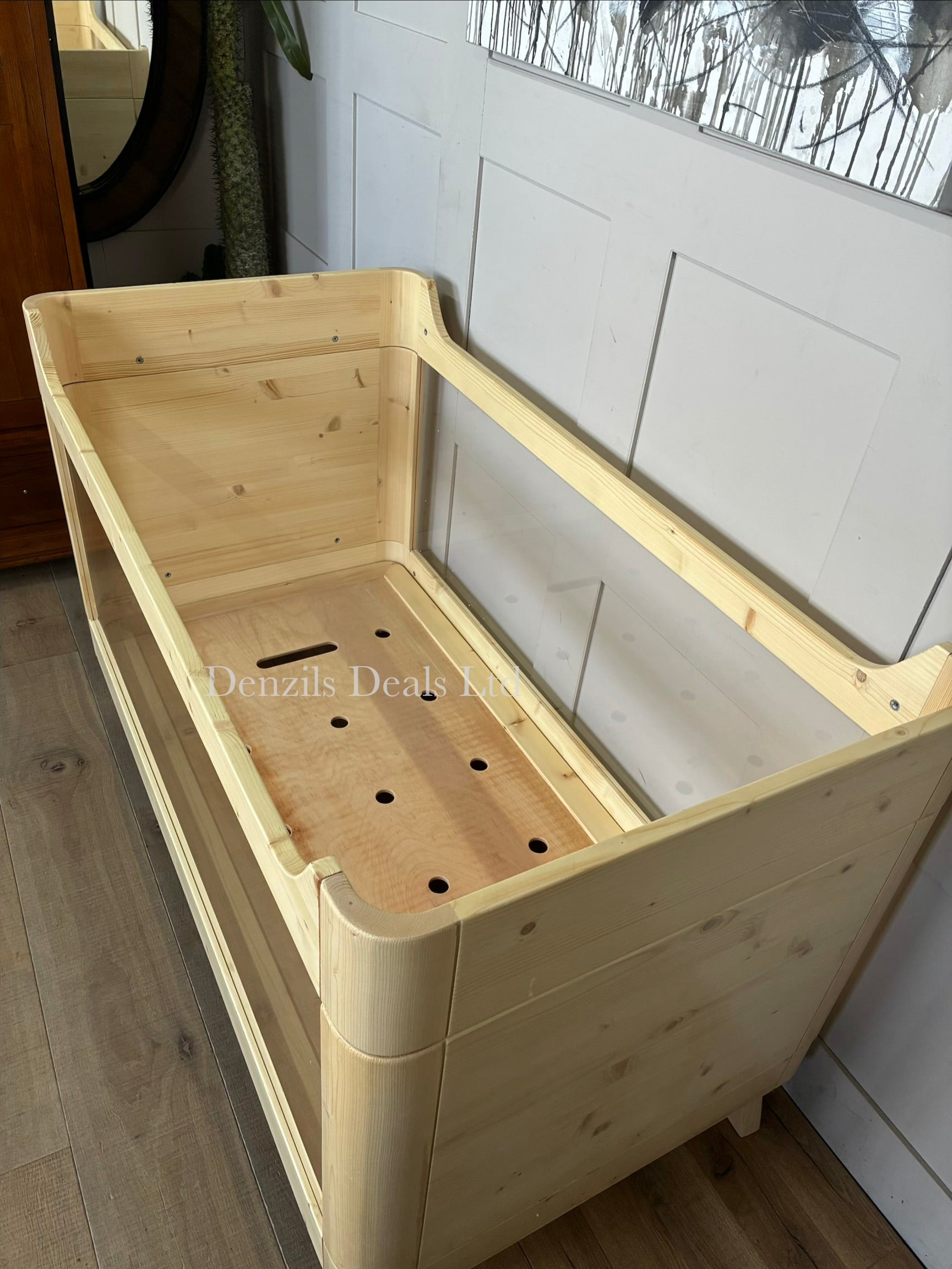 A modern Scandinavian-style SAZY baby cot bed made from natural spruce wood, featuring clear, transparent acrylic sides for full visibility.