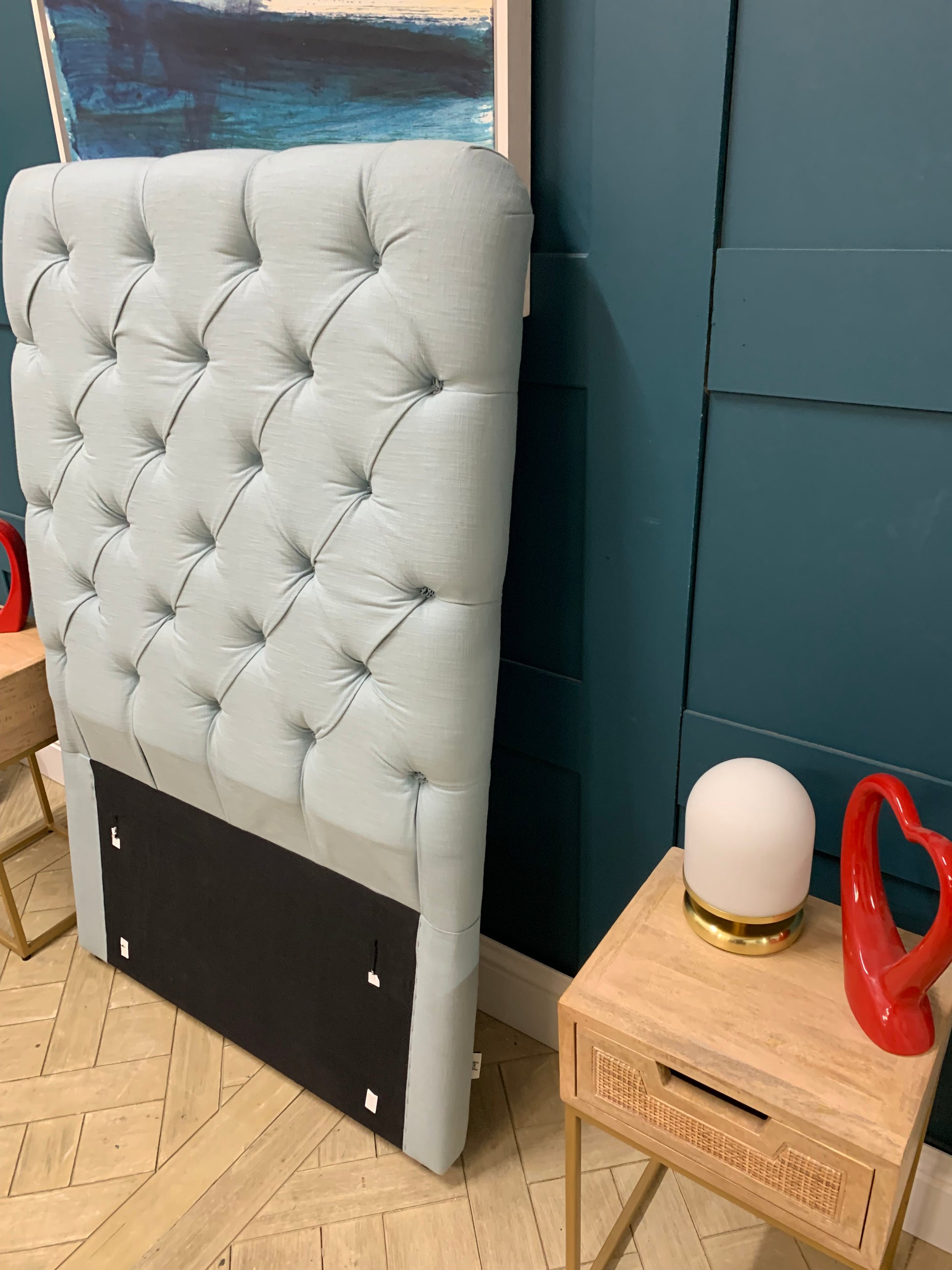 Single Loaf Pillow Talker headboard in light blue fabric with a softly padded squish and curved edges.
