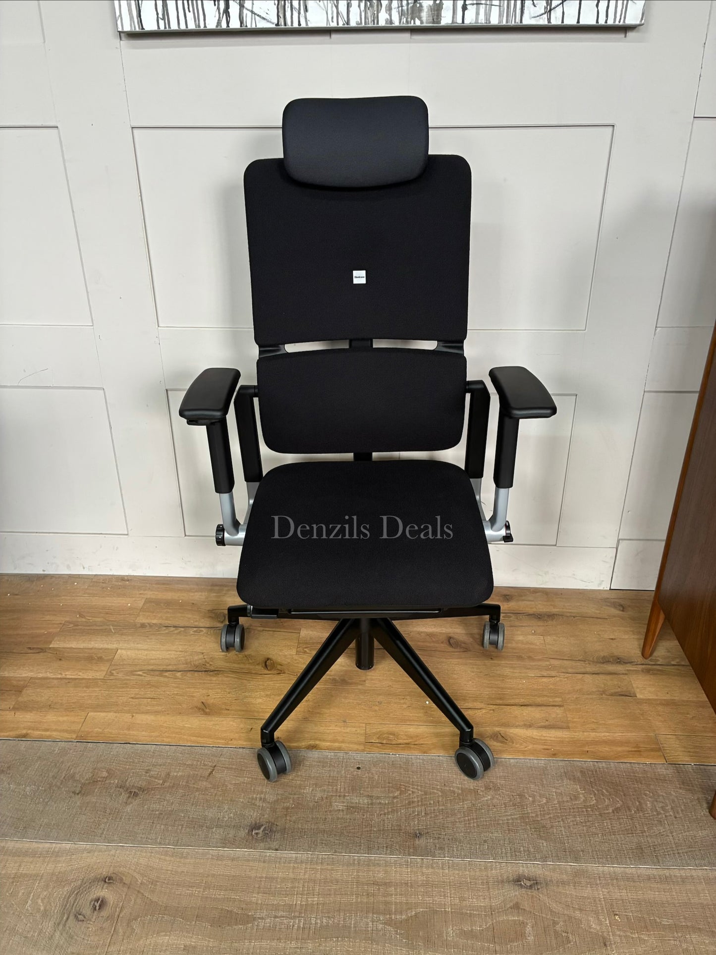 Steelcase Please ergonomic office chair in black fabric with an adjustable headrest.
