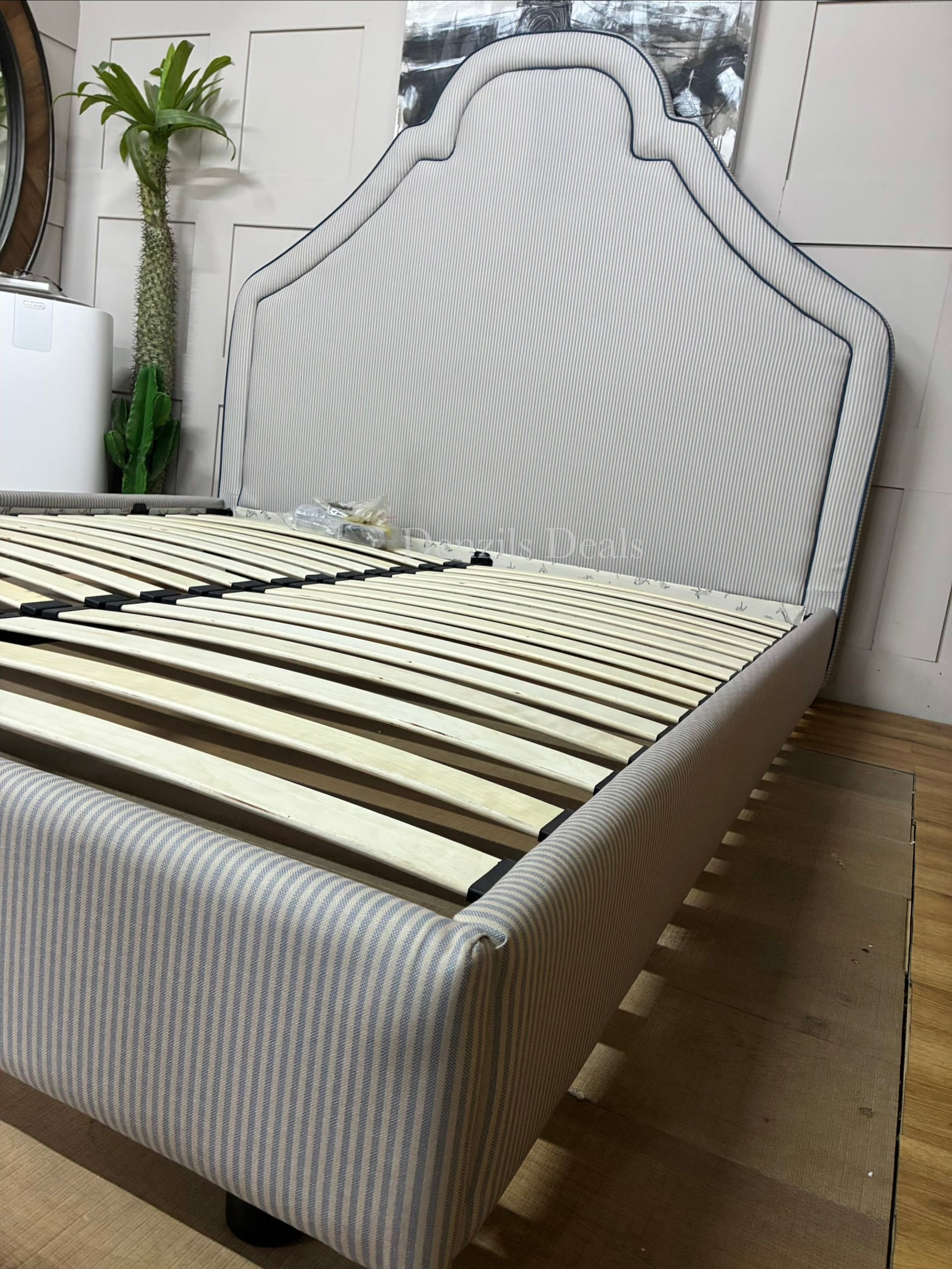 DFS Upholstered super king bed frame in a vibrant Joules hand-drawn blue ticking stripe  fabric with a dramatic tall headboard and sleek dark wood carved feet
