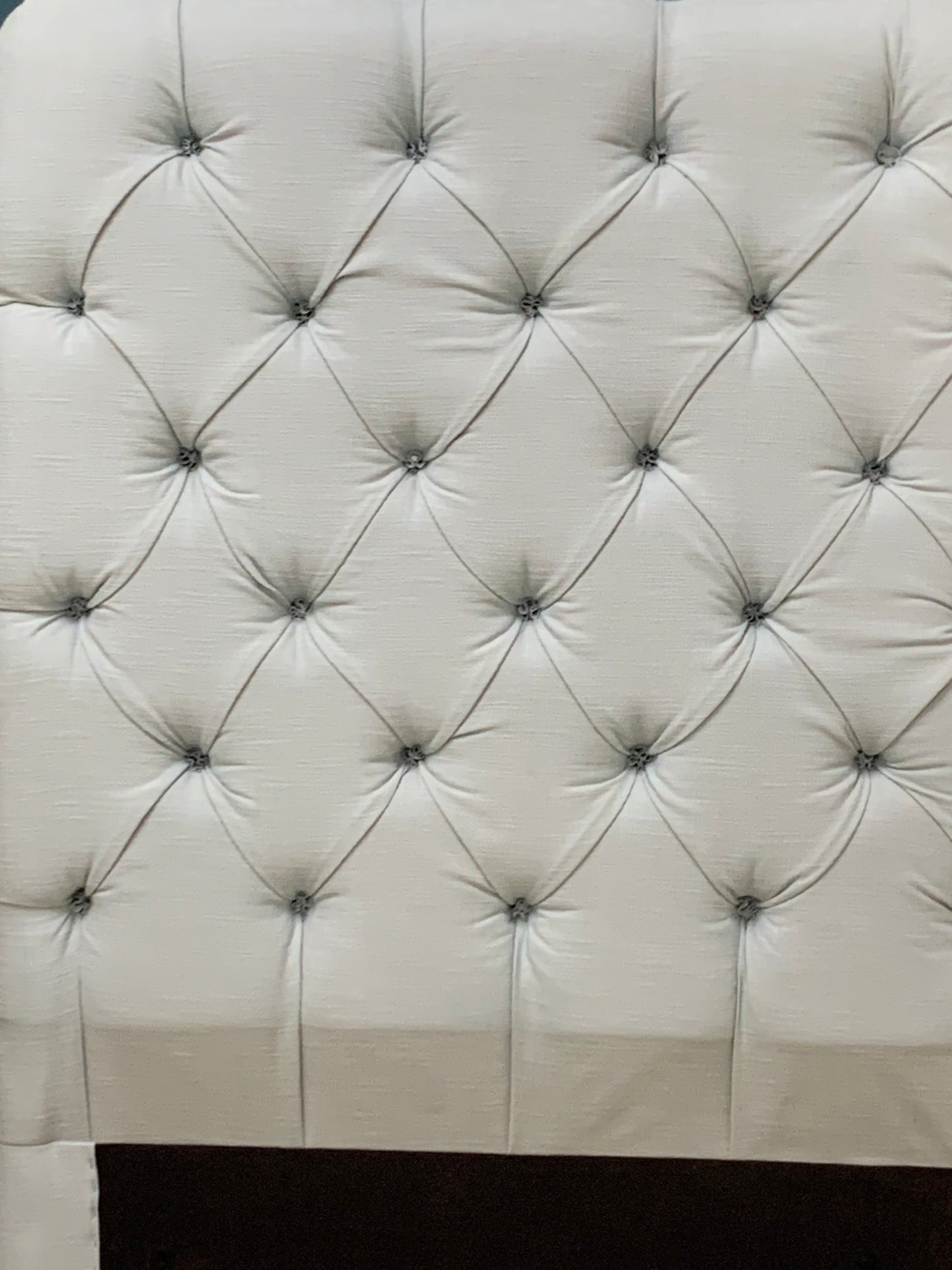 Tall Loaf single headboard upholstered in light blue cotton-linen fabric. It features a soft, generously padded, rectangular shape with laid-back, curved edges and a French seam