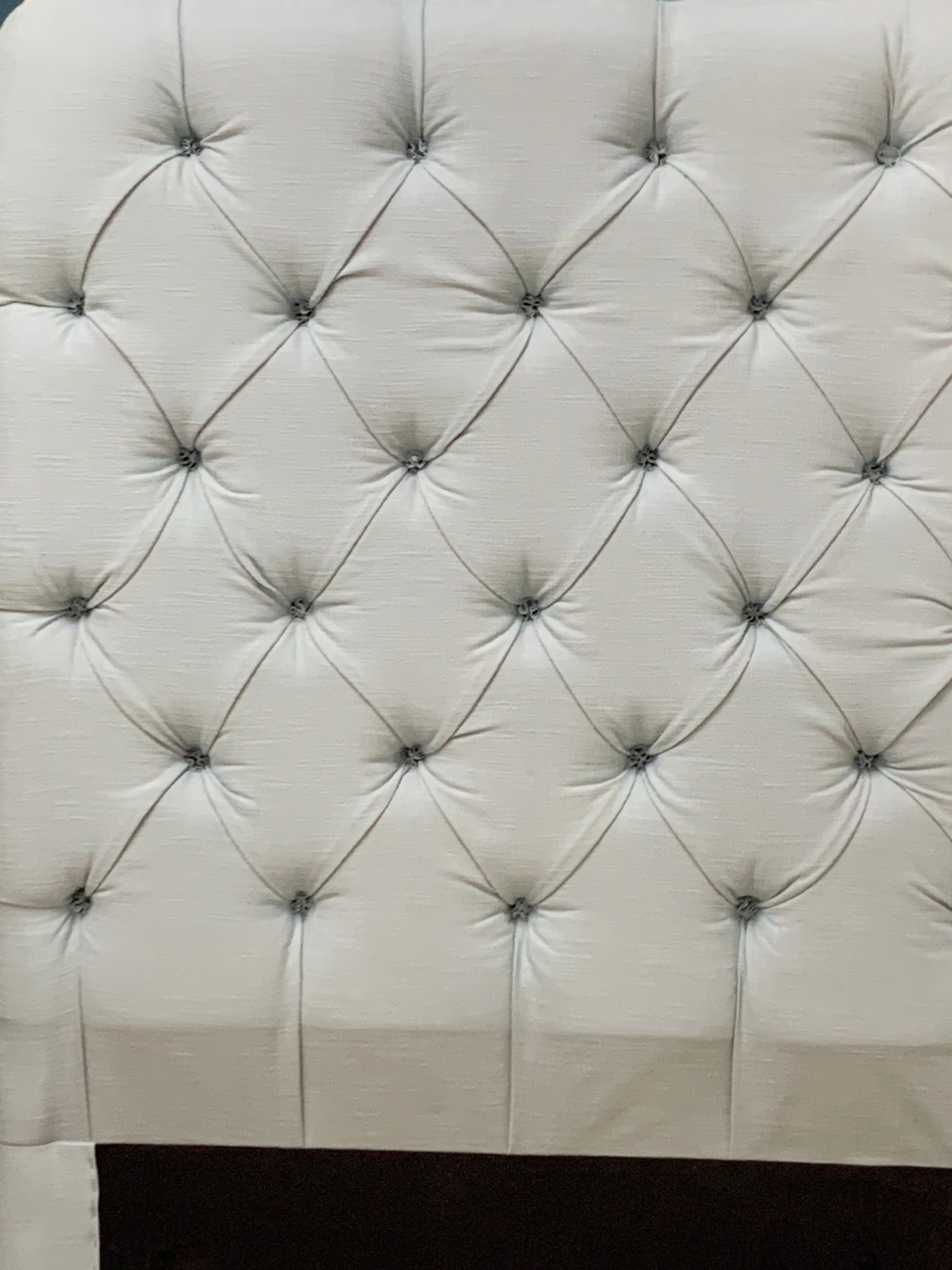 Tall Loaf single headboard upholstered in light blue cotton-linen fabric. It features a soft, generously padded, rectangular shape with laid-back, curved edges and a French seam