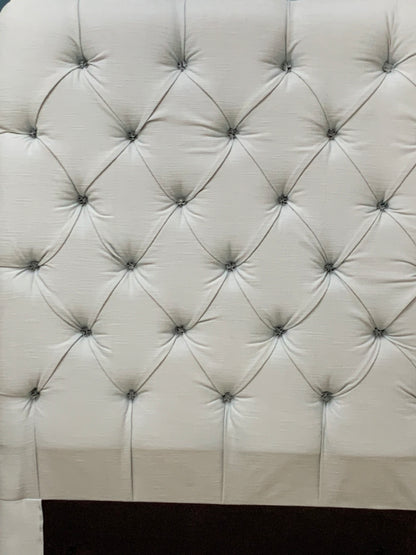 Tall Loaf single headboard upholstered in light blue cotton-linen fabric. It features a soft, generously padded, rectangular shape with laid-back, curved edges and a French seam