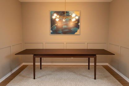 The AM.PM Yolo walnut dining table fully extended to its 10-seater configuration, highlighting the seamless wood grain center extension panels.