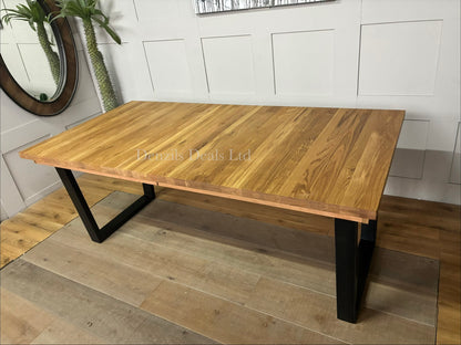 The John Lewis Calia oak dining table shown fully extended to seat 10 people, highlighting the center extension leaf slot."