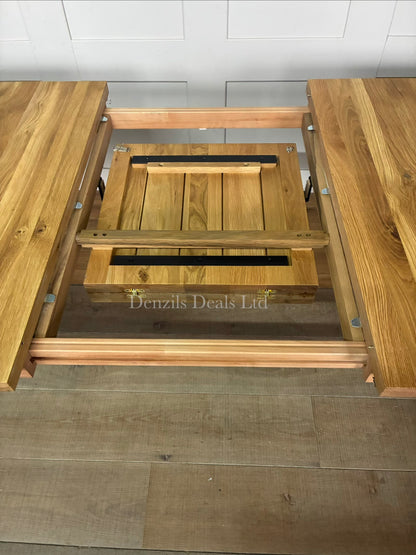 The John Lewis Calia oak dining table showing the extension leaf, highlighting the center extension leaf slot."