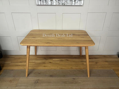 The John Lewis Greenwood solid oak dining table styled in a bright dining room, showcasing its minimalist mid-century design, round top, and light Bianco oil finish, surrounded by matching chairs