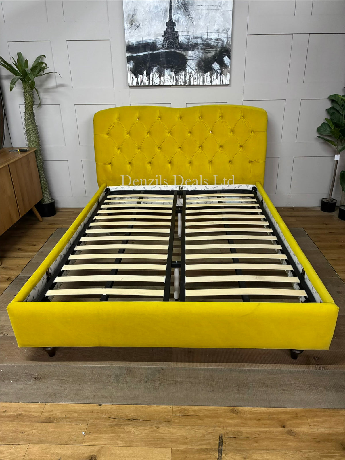 The Joules Windsor Bed Frame in mustard yellow velvet is a statement piece featuring a plush, Chesterfield-style button-back upholstered headboard