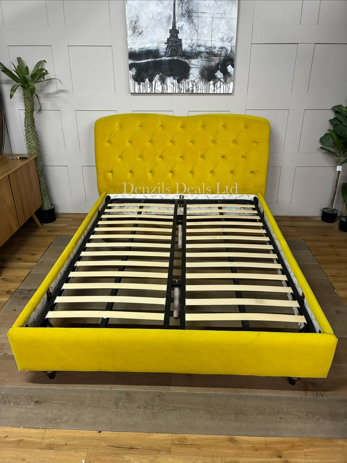 The Joules Windsor Bed Frame in mustard yellow velvet is a statement piece featuring a plush, Chesterfield-style button-back upholstered headboard