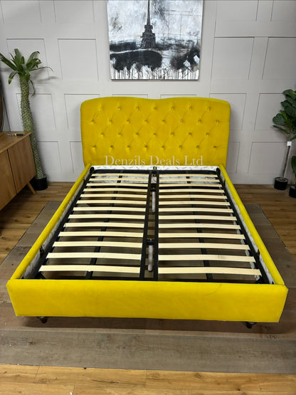 The Joules Windsor Bed Frame in mustard yellow velvet is a statement piece featuring a plush, Chesterfield-style button-back upholstered headboard