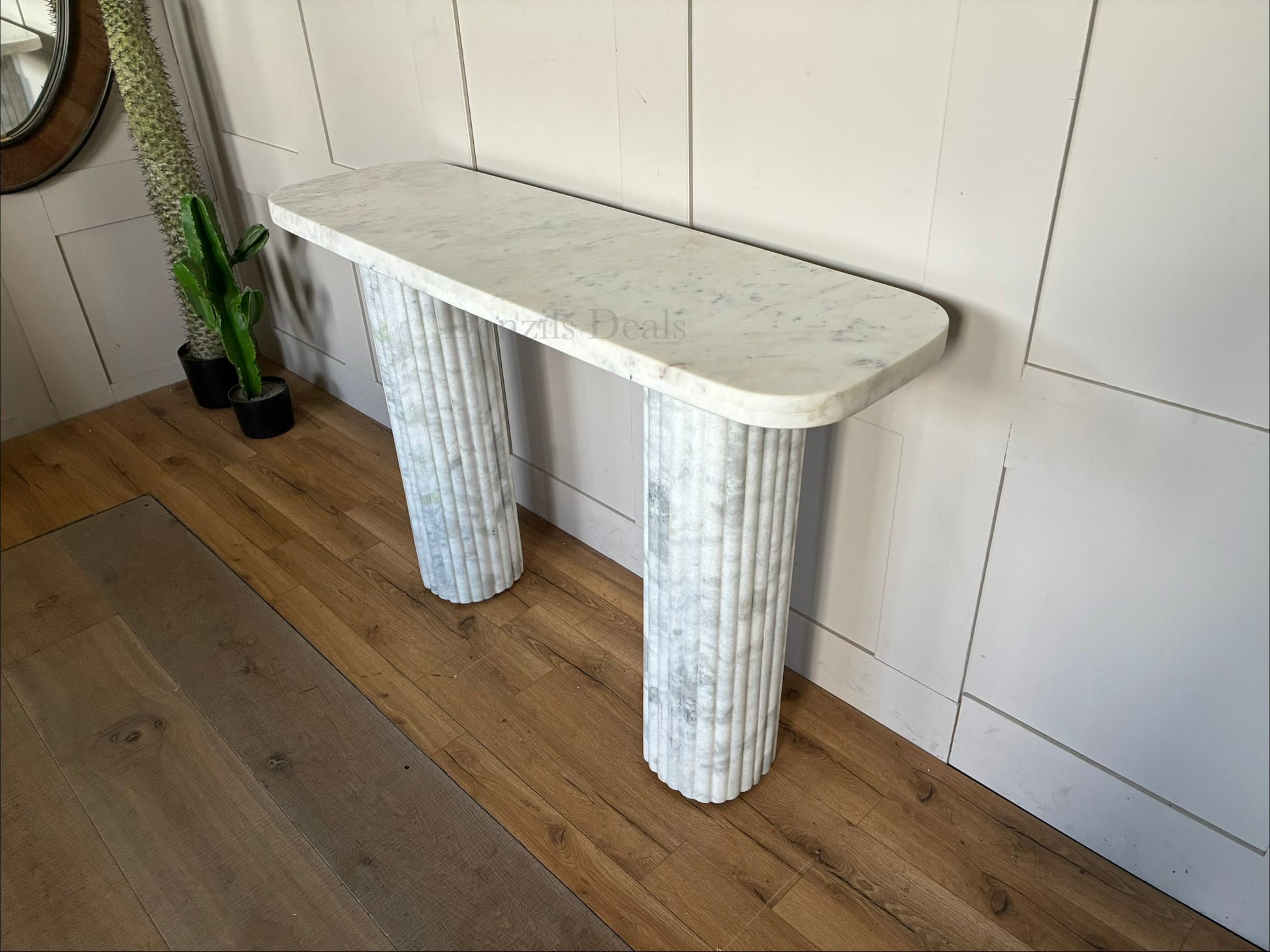 The Kanta fluted marble console table from Anthropologie, featuring sculptural block legs and a smooth rectangular top in natural stone