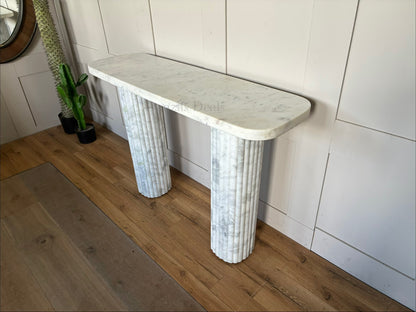 The Kanta fluted marble console table from Anthropologie, featuring sculptural block legs and a smooth rectangular top in natural stone