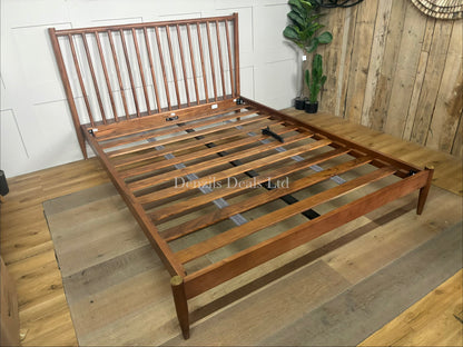 The Swoon Cartwright king-size bed frame in dark brown acacia wood. The bed combines traditional spoked styling with sleek contemporary lines, showcasing a high headboard with clean vertical slats and slim legs.