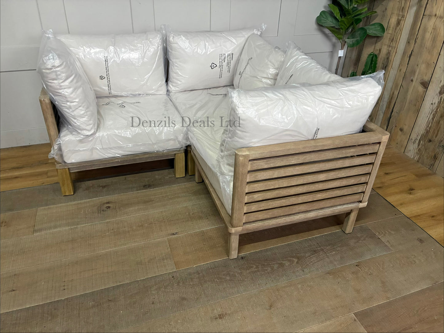 Three low-slung modular garden corner chair made from brushed eucalyptus wood with a modern slatted design and thick seat and backrest cushions, combined to make a perfect corner sofa