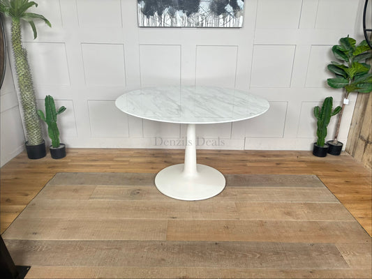 Traver round dining table by Nick Scali, featuring a smooth, matte travertine-wrapped top resting on a sculptural, wave-like white-washed oak pedestal base.
