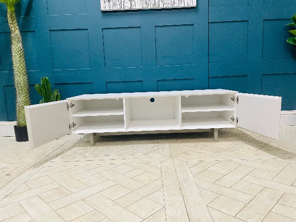 Media console by Content by Terence Conran in white with a geometric diagonal pattern on the doors and exposed wooden legs