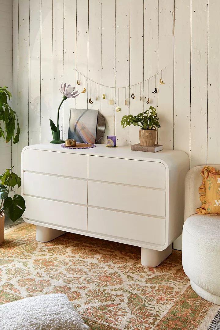 Urban Outfitters Huron white mango wood 6-drawer dresser with curved corners and cylindrical feet.