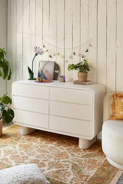 Urban Outfitters Huron white mango wood 6-drawer dresser with curved corners and cylindrical feet.
