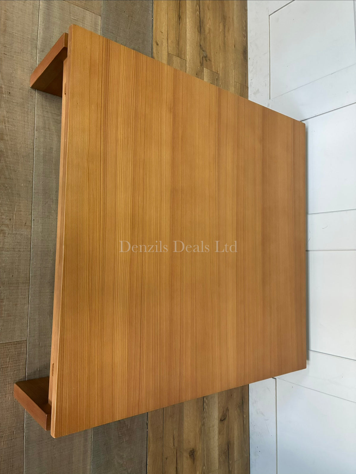 A West Elm Ainsley square coffee table measuring 102 cm with a low-profile design. The table showcases a streamlined top suspended over a structured wood frame with visible craftsmanship detailing, all finished in a warm, rich nutmeg brown veneer.
