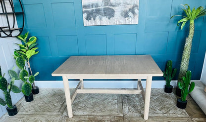 West Elm Hargrove extendable wood dining table shown fully extended, showcasing the smooth, continuous light oak veneer grain patterns and structural support underframe.