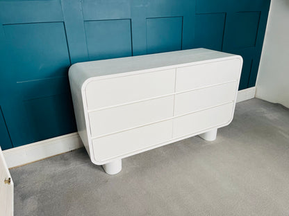 White 6-drawer wooden dresser with grooved pulls and a lacquered finish