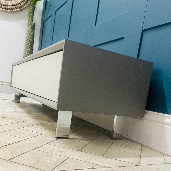 Wide Dante TV cabinet in a modern living room setting, supporting a large screen television. Side view 