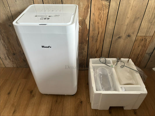 White Wood's Como 12K portable air conditioner on sturdy wheels, featuring a sleek modern design, a digital touch control panel on top, and a front-facing display, with the exhaust hose attached to a window kit