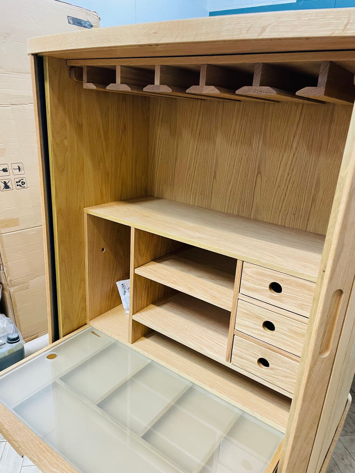 Wooden desk top storage unit with grey finish and sliding tambour doors.