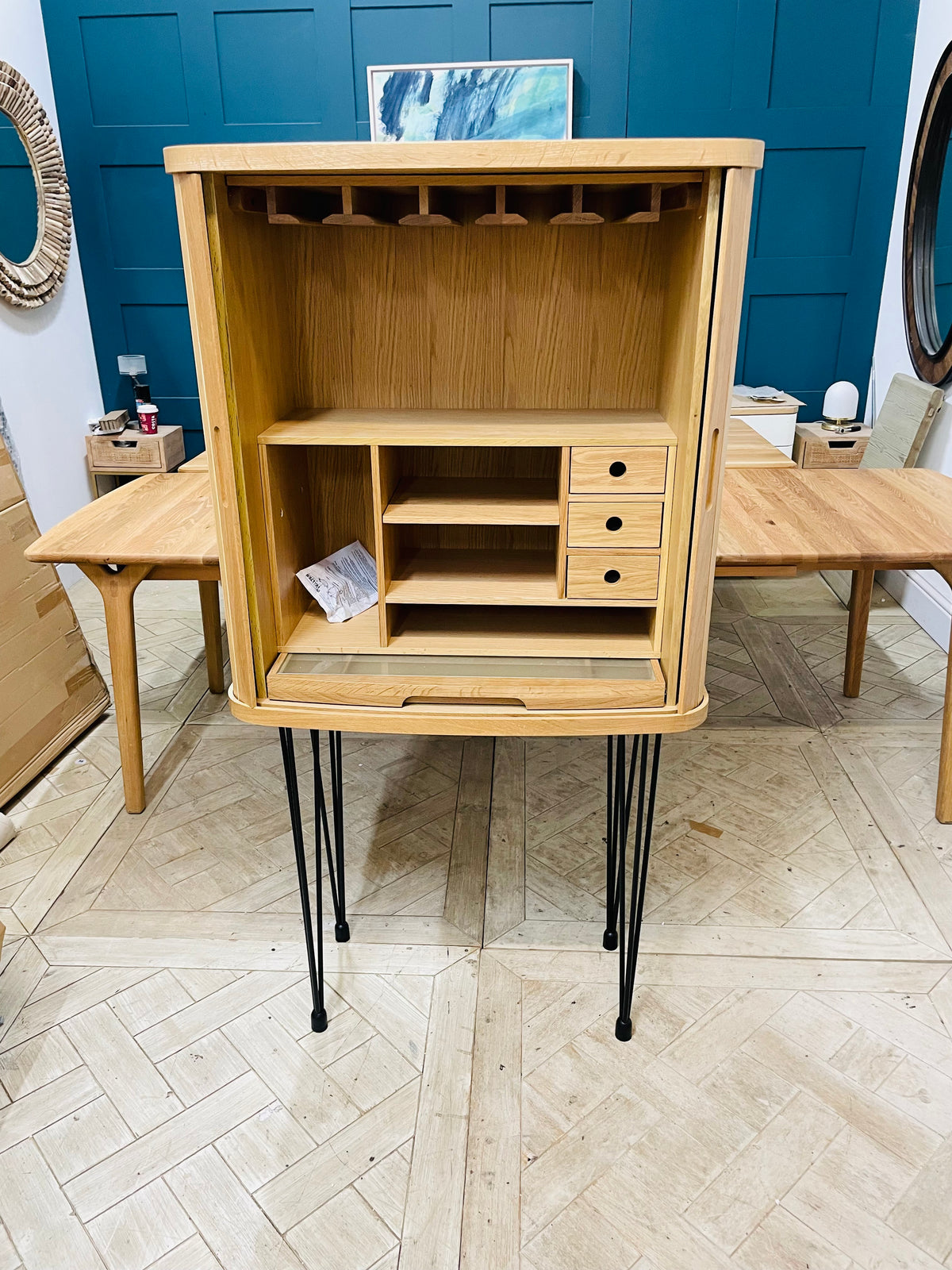 Wooden desk top storage unit with grey finish and sliding tambour doors.